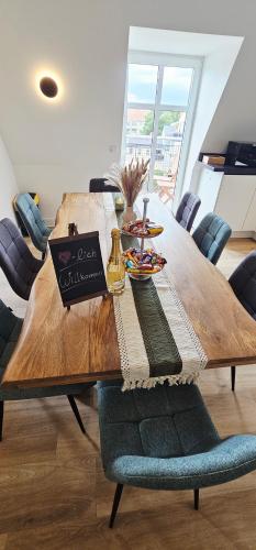 a wooden table with a bottle of wine on it at Lace Apartments Stilvoll in der Spitzenstadt Plauen in Plauen