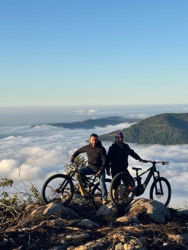 two men standing on top of a mountain with their bikes at Flora Handüzü Resort & Wellness Bungalow Hotel in Rize