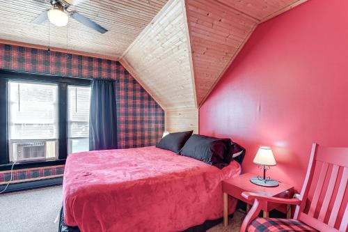 a bedroom with a bed and a red wall at Cozy Hart Getaway with Fire Pit Less Than 1 Mi to Lake! in Hart