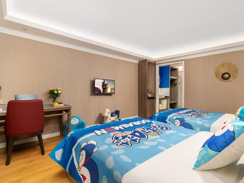 a bedroom with two beds and a desk with a computer at Jinjiang Metropolo Wuyishan Sangu Resort Hotel in Wuyishan