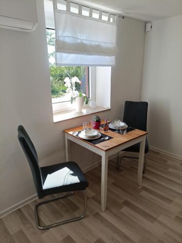 a dining room table with two chairs and a window at FeWo-Exter, Panoramablick, freies Parken, Nähe A2Herford Ost, gute LKW-Rangiermöglichkeiten, 17Minzum Messezentrum BS in Vlotho