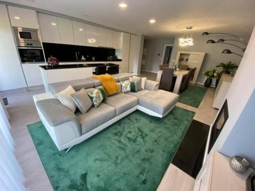 un salon avec un canapé blanc et un tapis vert dans l'établissement AgrelaBeach, à Marinhas