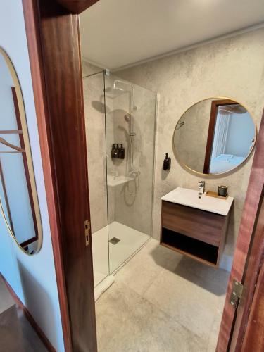 a bathroom with a shower and a sink and a mirror at MadeiraLife in Seixal