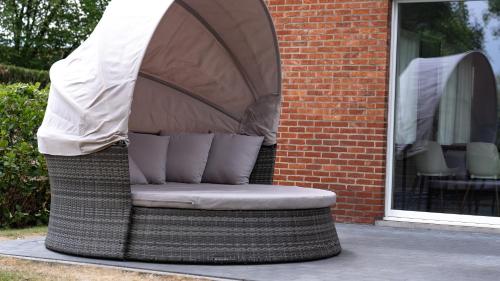 a wicker chair sitting outside of a building at Nethehuis in Kasterlee