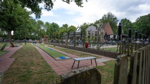 a park with a playground with a bench and a fence at Nethehuis in Kasterlee