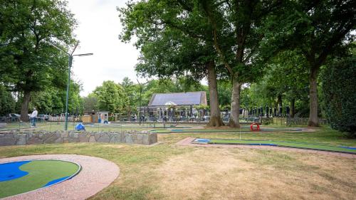 a park with a playground with trees and a building at Nethehuis in Kasterlee