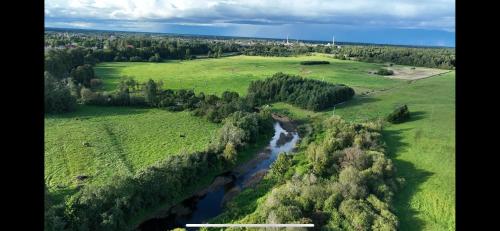 an aerial view of a river in a field at Pievu namelis in Venta