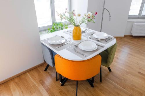 a table with plates and a vase with flowers on it at Studio K2 in Brno
