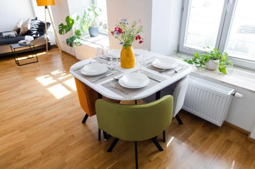 a dining room table with plates and a vase with flowers at Studio K2 in Brno