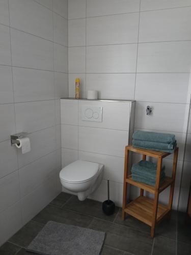 a small bathroom with a toilet and a stool at Ferien- und Pferdehof Egelkraut "Feriendomizil am Meer" in Wangerland