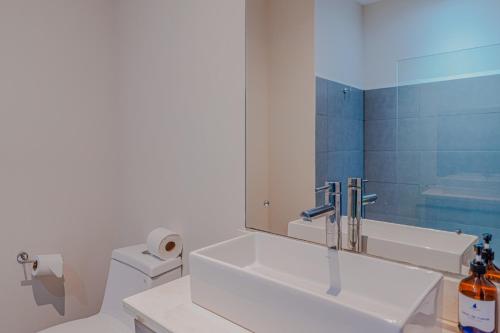 a bathroom with a sink and a toilet and a mirror at Puerto Azul 155 in El Roble