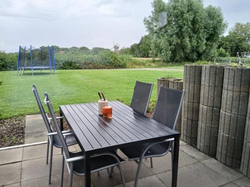 a wooden table and chairs on a patio at Ferien- und Pferdehof Egelkraut "Feriendomizil am Meer" in Wangerland
