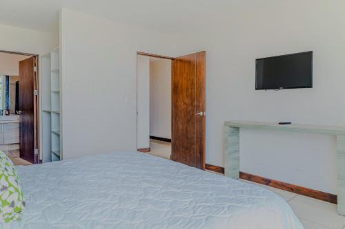 a bedroom with a bed and a tv on a wall at Puerto Azul 138 in El Roble
