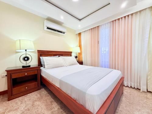 a bedroom with a large bed and a window at Sol y Confort Suites in Machala