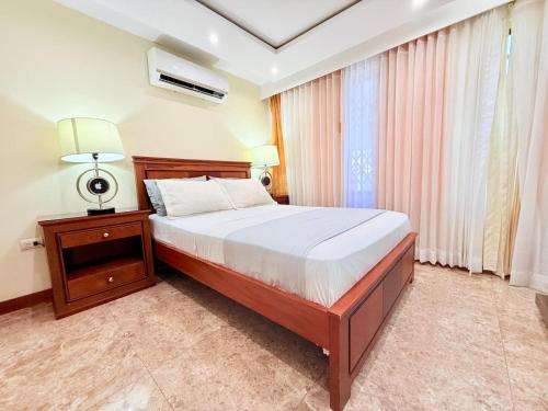 a bedroom with a large bed and a window at Sol y Confort Suites in Machala