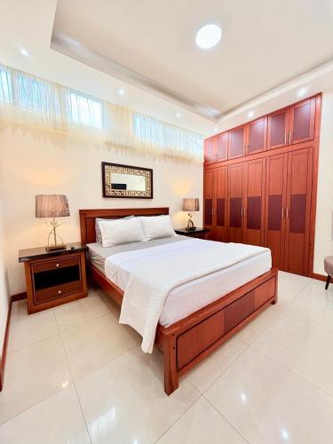 a bedroom with a large bed with wooden cabinets at Sol y Confort Suites in Machala