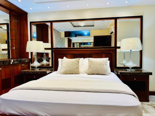 a bedroom with a large bed with two lamps at Sol y Confort Suites in Machala