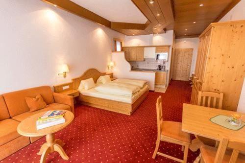 a hotel room with a bed and a table at Haus Bergland in Bad Kleinkirchheim