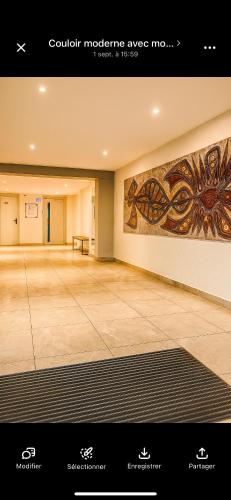 a large empty room with paintings on the walls at Vue sublime mer in Canet-en-Roussillon