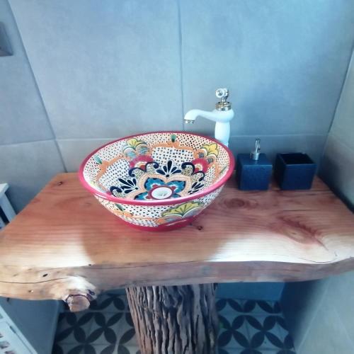 a bathroom with a bowl sink on a wooden table at Domo Conguillío in Melipeuco