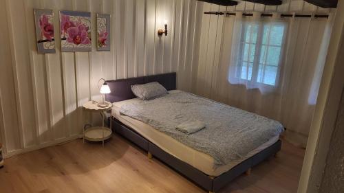 a bedroom with a bed and a table with a lamp at Room in cosy traditional swiss house 