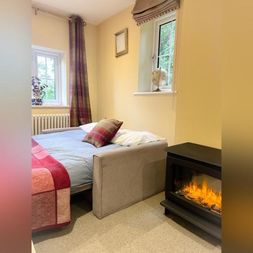 a bedroom with a bed and a fireplace at Peak District Period Property near Chatsworth House in Bakewell