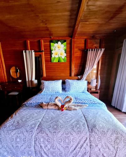 a woman laying on a bed with a flower on it at Pondok Denly by Pigeon in Nusa Dua