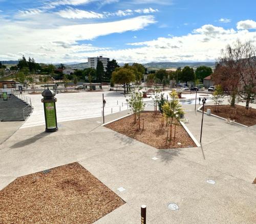 a park with trees and a parking lot at Hotel Le Midi Clermont-Cournon in Cournon-dʼAuvergne