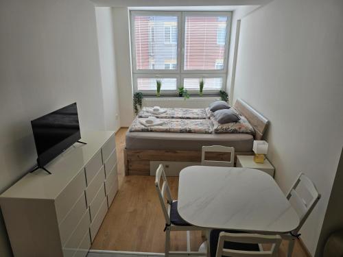 a small bedroom with a bed and a table at Spirit apartments Brno, with parking in Brno