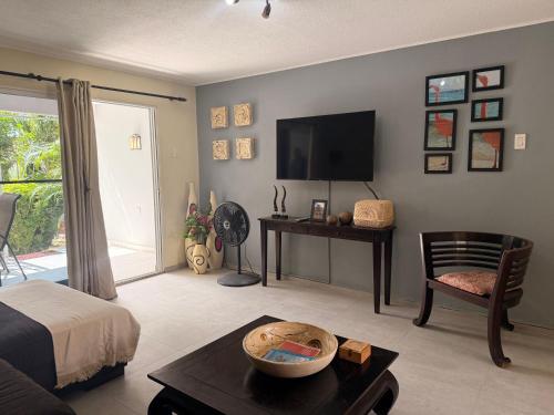 ein Wohnzimmer mit einem Bett und einem Fernseher in der Unterkunft Bon Bini na Curacao in Willemstad