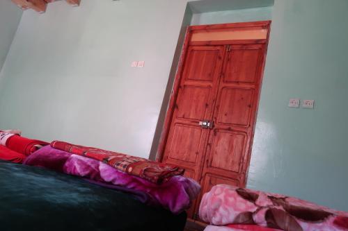 a red wooden door in a room with a couch at Gite Megdaz in Megdaz