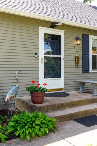 a house with a bird standing on the front porch at Crane Haven - Walk to CyRide Games & Grill in Ames