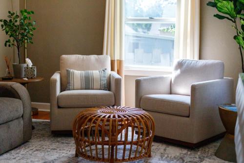 a living room with two chairs and a basket at Crane Haven - Walk to CyRide Games & Grill in Ames