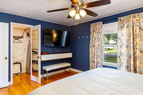 a blue bedroom with a bed and a ceiling fan at Crane Haven - Walk to CyRide Games & Grill in Ames