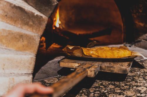 a pie in a pan in a stone oven at Limeri Traditional Guest House in Monólithos