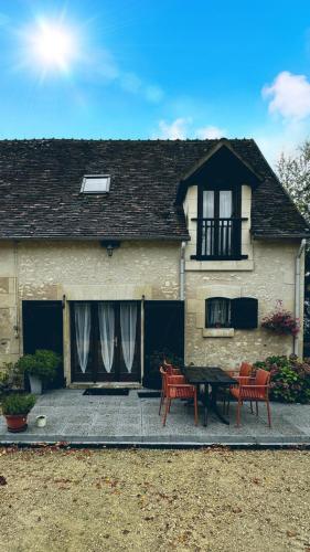 a house with a patio with two chairs and a table at Le Cormier in Obterre