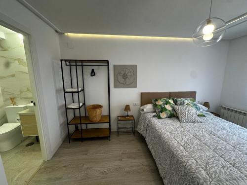 una camera da letto con un letto e un bagno con un lavandino di Sweet Habana Puertollano a Puertollano