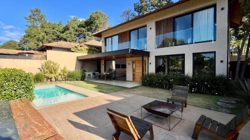 テレゾポリスにあるCasa 08 Monte Boa Vista - Piscina Privativa, Sauna e Ofurô de Imersãoの裏庭にプールがある家