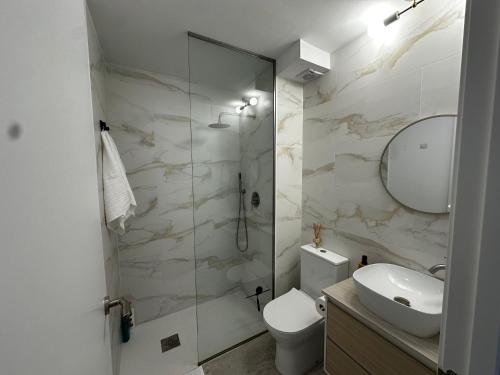 un bagno con un water, un lavandino e uno specchio di Sweet Habana Puertollano a Puertollano