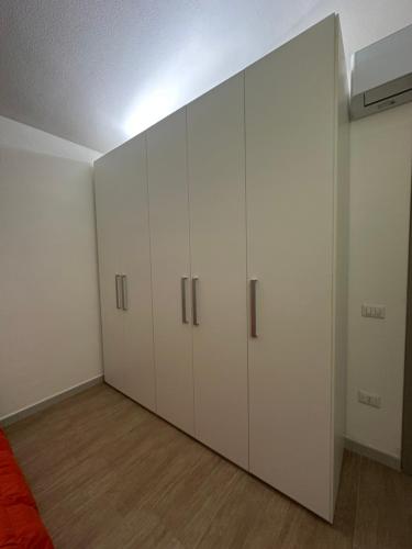 an empty room with white cabinets and wood floors at Casa Nuditta in Nuditta