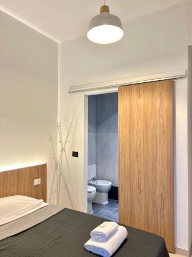 a bedroom with a bed and a bathroom with a toilet at Hotel Brivio in Milan