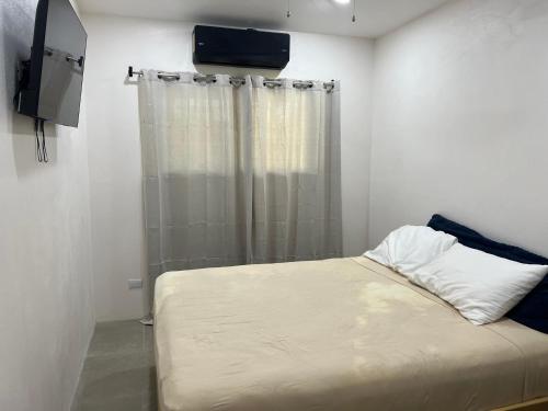 a small bedroom with a bed and a curtain at Pura Vida 2 Bed 2 Bath Montezuma in Montezuma