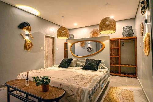a bedroom with a bed and a round mirror at Amshiga 1 in Jimbaran