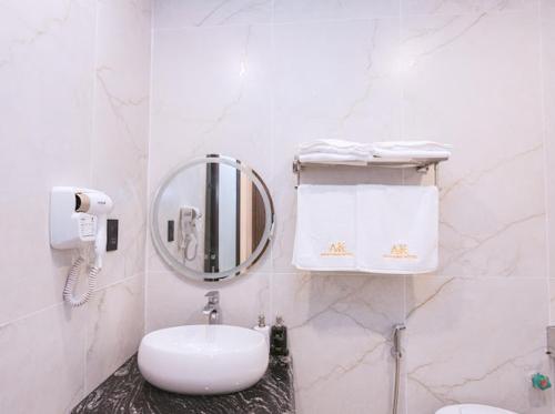a white bathroom with a sink and a mirror at An Khang Hotel in Quang Ba