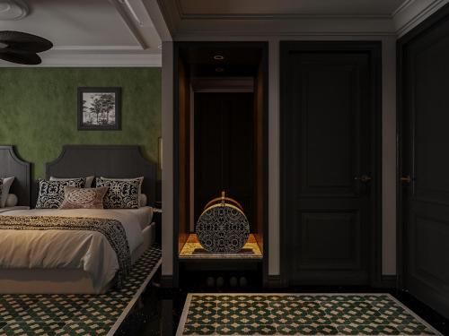 a bedroom with a bed and a door with a table at L'Heritage Riverside Hoi An in Hoi An