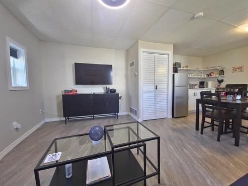a living room with a table and a television at Cozy home on a quiet street minutes to DT Kingston in Kingston