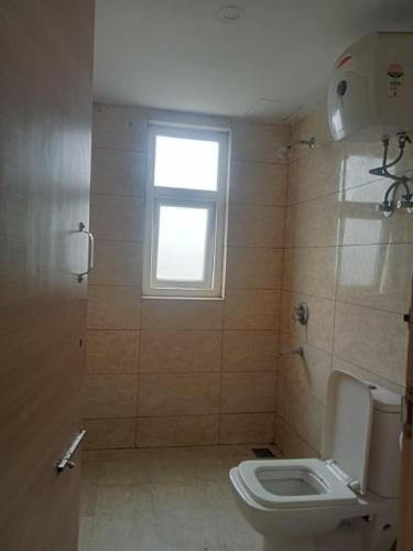 a bathroom with a toilet and a window at Vrindavan Stay in Vrindāvan