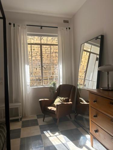 a living room with a chair and a mirror at Harbour of Colours in Pieta