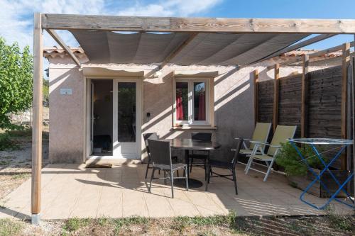 a patio with a table and chairs on it at Gîte Chêne ou Murier in Les Vans
