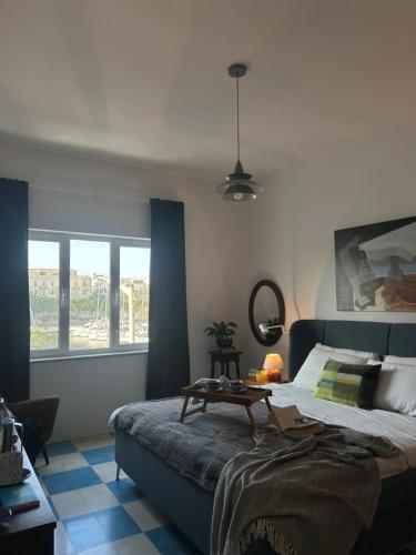 a bedroom with a bed and a table in it at Harbour of Colours in Pieta